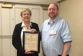 Susan Dawson Tibbits receiving a plaque for her work as chair of elder law from Steve Iden, current chair.