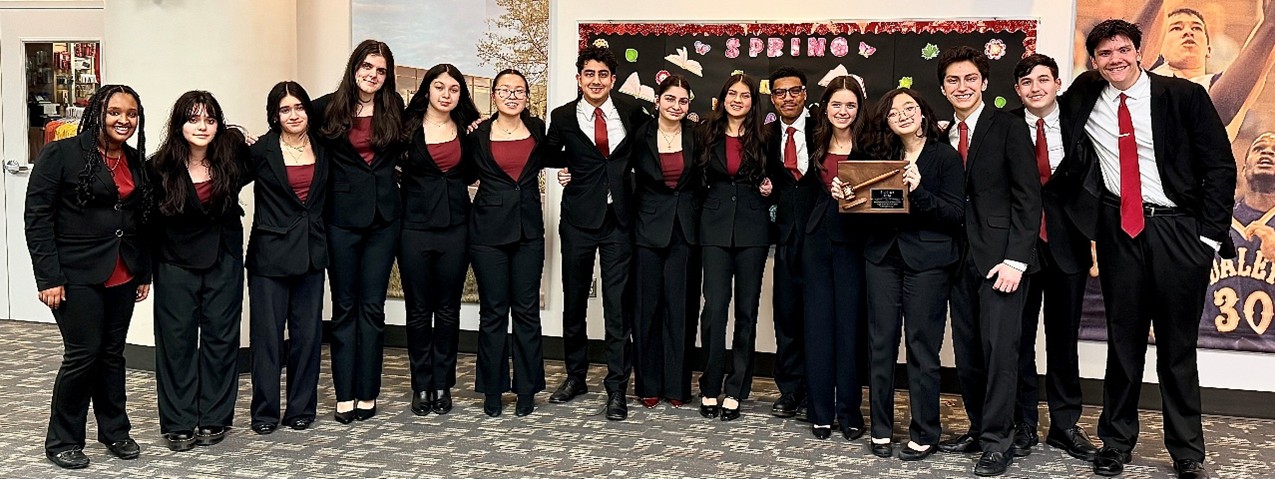 A photograph of the team from Niles West High School with their coach and award. 