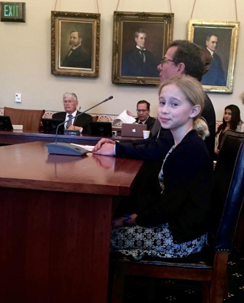 Eleven-year-old Madeline Birnbaum sits with her father, Illinois Court of Claims Chief Justice Peter Birnbaum, in the Illinois Senate Chambers during the confirmation of his appointment by Governor Bruce Rauner. 
