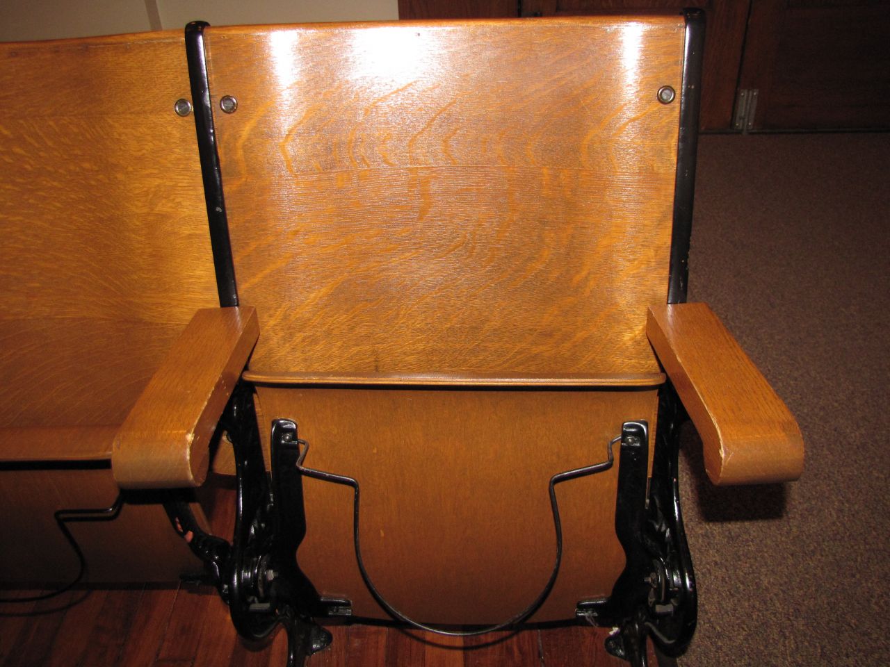 Close-up of seats with antique hat holder underneath