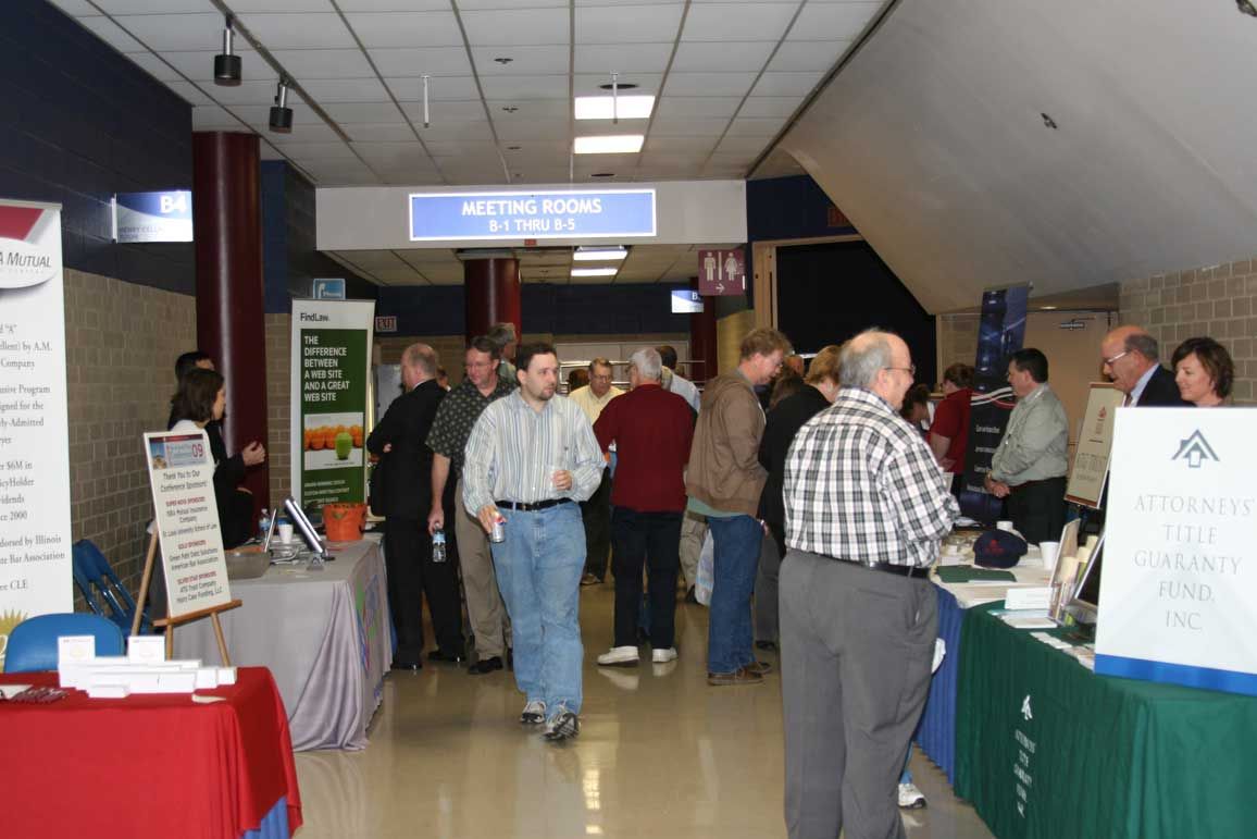 Exhibitors showcase their services to attendees during a break between seminars.