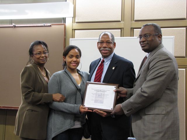 Angela Buford (left) and Lawrence Hill (right) present an award to John Marshall Law School for hosting the Law Day Luncheon.