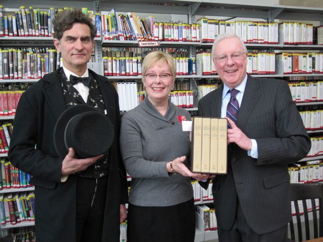 President O'Brien (right) presents the "The Papers of Abraham Lincoln" to Edwardsville Public Library Director Deanne Holshauser with the help of Lincoln re-creator Joe Woodard.