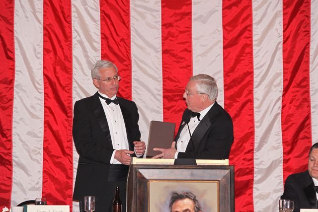 ISBA President John O'Brien presents the "The Papers of Abraham Lincoln" to Peoria County Bar Association President Timothy J. Cassidy at the 102nd Annual Lincoln Memorial Banquet. 