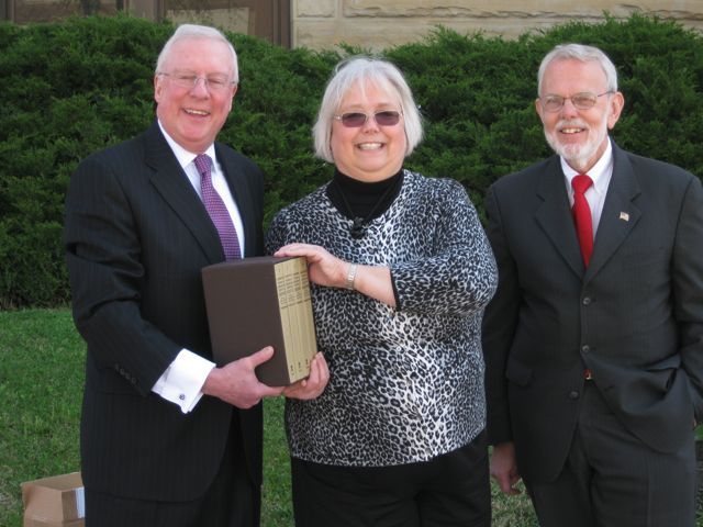 President O'Brien presents the four-volume set to Dee Runnels, president of the Moline Public Library Board, and Robert Park, President of the Rock Island County Bar Assocation.