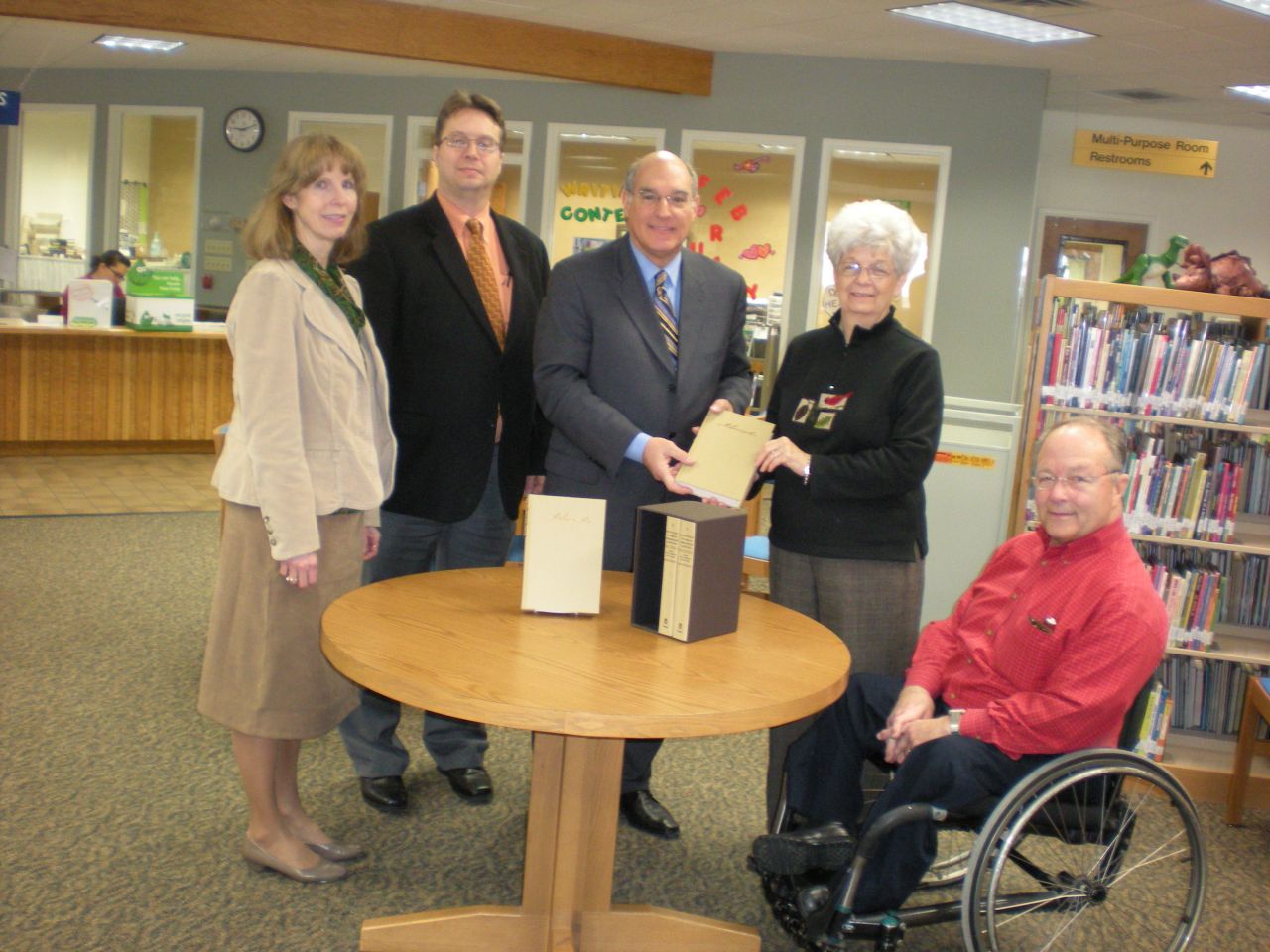 ISBA President-elect Mark Hassakis (center) presented the four-volume set to the Olney Public Library on Feb. 17 as a gift from the ISBA and the Illinois Bar Foundation. Accepting the books is Judy Whitaker (second from right), library director. On hand for the presentation were (from left) Judges Kimbara G. Harrell and Larry D. Dunn, both of the 2nd Judicial Circuit, and Olney attorney Tom Weber.  