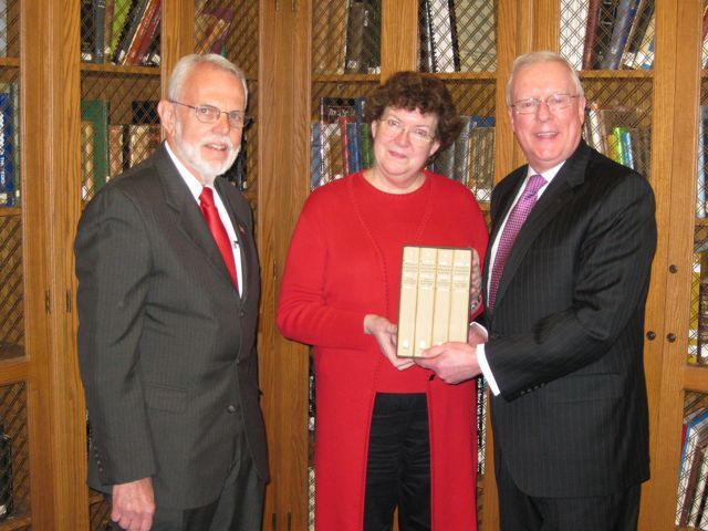 Robert Park, President of the Rock Island County Bar Association, and Ava Ketter, director of the Rock Island Public Library, receive the four-volume set from President O'Brien on Thursday, April 8.