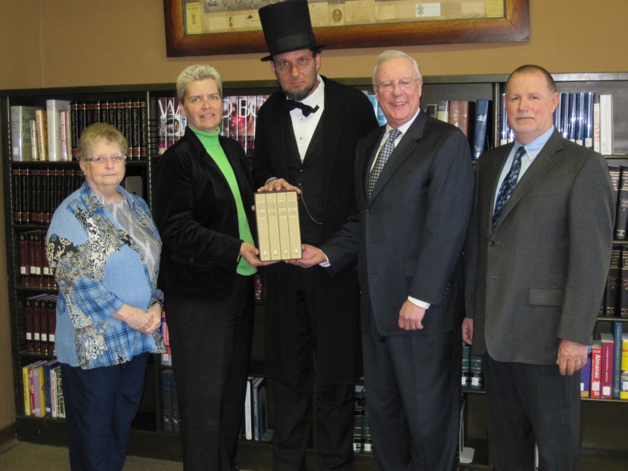 President O'Brien also presented a set of books to a board member of the Prophetstown library, the Henry C. Adams Memorial Library. Accepting the set of books was a board member (at left) Sharon James-Reedy. Also in the photo (from left) Jennifer Slaney, head librarian, Sterling Public Library; Abe Lincoln re-creator, George Buss; John O