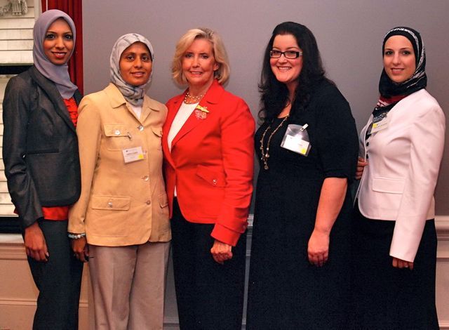Amina Saeed (in yellow), President of the Muslim Bar Association of Chicago, along with fellow members, visits with Lilly Ledbetter
