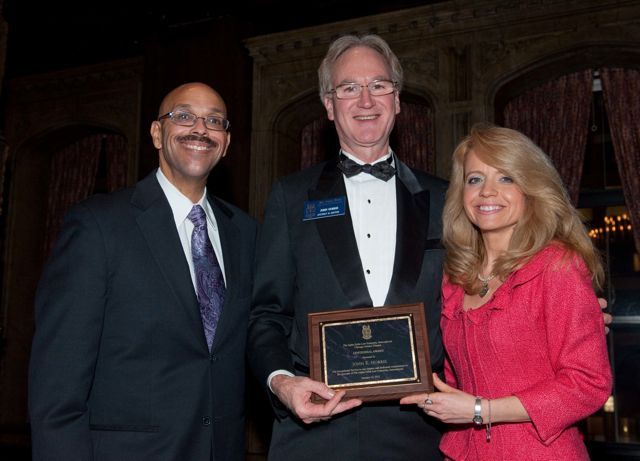 Pierre Priestley and Michele Jochner present a Chicago Alumni Chapter Centennial Award to past Chapter Justice, John K. Norris