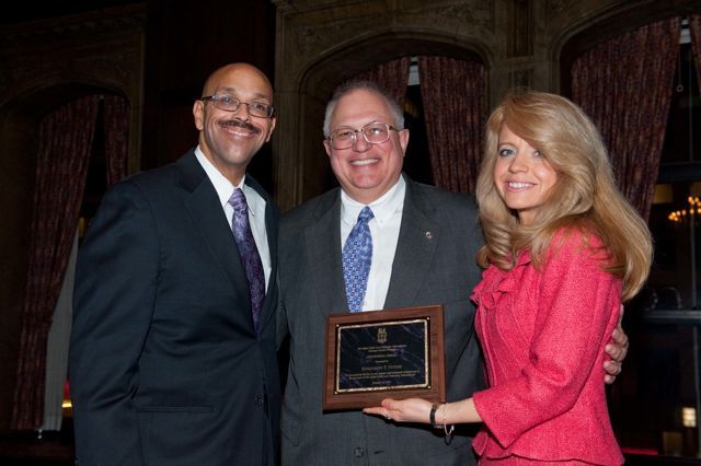 A Chicago Alumni Chapter Centennial Award is presented by Pierre Priestley and Michele Jochner to past Chapter Justice, Benjamin Hyink