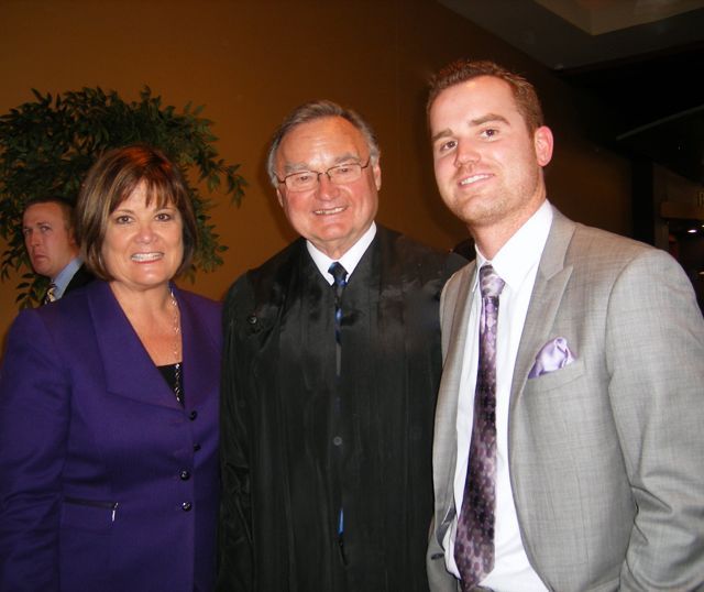 Supreme Court Justice Lloyd Karmeier congratulates new admittee Bryce Joiner and his mother Barbara.
