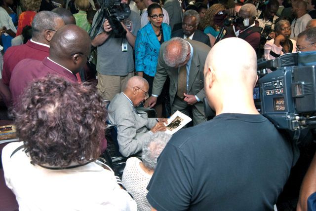 Judge Leighton is surrounded by well-wishers and media after the event.