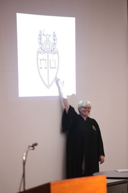 Leah Farmer, Justice of the Story Chapter at DePaul University College of Law, explains the symbols in the fraternity's coat of arms.