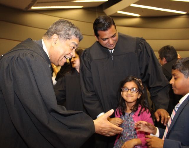 Chief Cook County Circuit Court Judge Timothy C. Evans greets Armaan, 9, as his sister, 5-year-old Sarina, and his father, Judge Mohammed M. Ghouse look on. Judge Ghouse was one of 13 associate judges sworn in Monday, May 9, 2016, at an event held in the James R. Thompson Center.