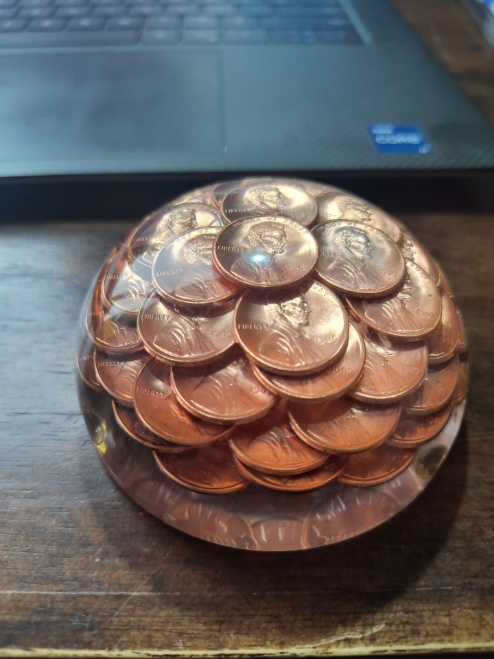 Michael Brandt: "Glass paperweight with pennies encased. A gift from my daughter years ago. All the pennies are the year 1989."
