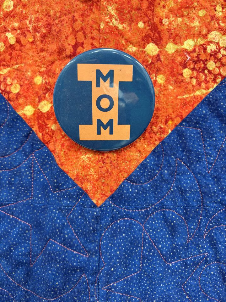 Debra Walker: "This button adorns my orange and blue quilt hanging on my chambers wall behind my desk. It is a vintage button I bought for my now deceased mother on Mom’s Weekend 1981 at University of Illinois, Urbana Champaign. My mother was an Illini Mom x4! Life comes full circle—I recently served as President of the Illini Moms Association. As a double Illini and an Illini Mom, this is a much-prized possession."