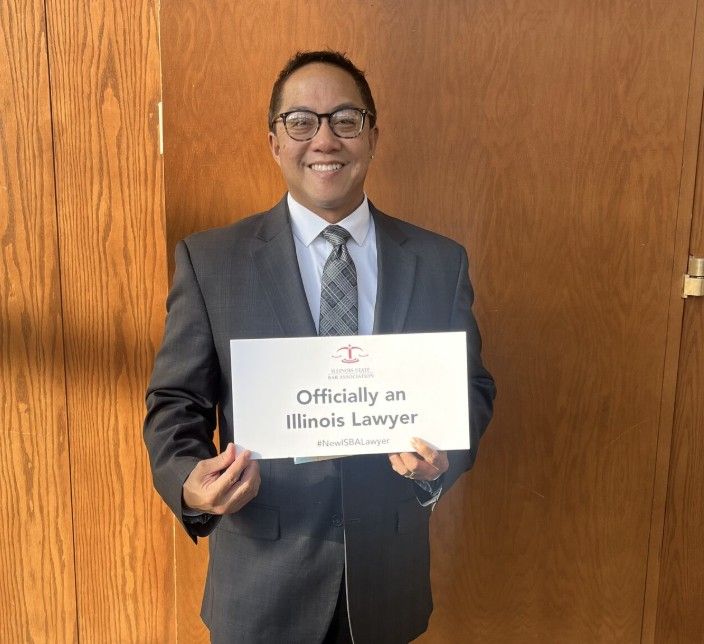 New lawyer Reynaldo holds up the ISBA sign!