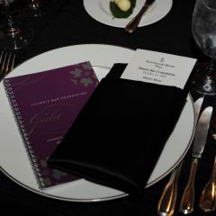 The program book and table setting reflected the black, white and purple color scheme.