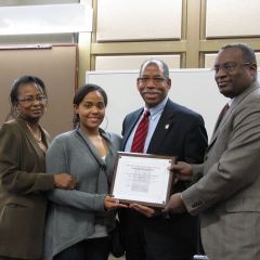 Angela Buford (left) and Lawrence Hill (right) present an award to John Marshall Law School for hosting the Law Day Luncheon.