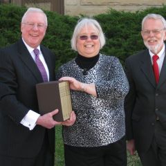 President O'Brien presents the four-volume set to Dee Runnels, president of the Moline Public Library Board, and Robert Park, President of the Rock Island County Bar Assocation.