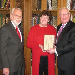 Robert Park, President of the Rock Island County Bar Association, and Ava Ketter, director of the Rock Island Public Library, receive the four-volume set from President O'Brien on Thursday, April 8.