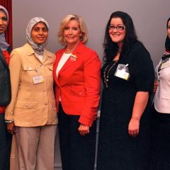Amina Saeed (in yellow), President of the Muslim Bar Association of Chicago, along with fellow members, visits with Lilly Ledbetter
