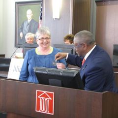 M. Carol Pope received a new name badge from outgoing IJA President Lewis Nixon