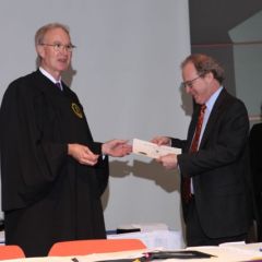 District XI Justice John K. Norris presents a membership certificate to DePaul University College of Law Dean Gregory Mark.