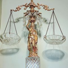 Michelle Rozovics: "After my Law School graduation, my mother and aunts went to the car and brought in a very heavy package, with many tiny tissue-paper-wrapped mini packages. They couldn’t stop laughing as I began unwrapping each gift. Tiny crystal teardrops on wires. OK, I like jewelry. Candy dishes? Then, the beautiful, golden, 2-foot-tall monstrosity. Her. They bought her at a second-hand thrift store and thought I would hate her. They thought she made a great joke gift. Nope. I love every gaudy, glorious inch of her. I have displayed her proudly in every office for 29 years. My Scales of Justice."